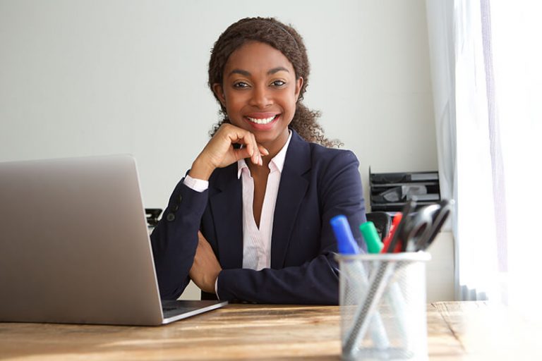 young-black-businesswoman-sitting-at-office-desk-SQZDS5W